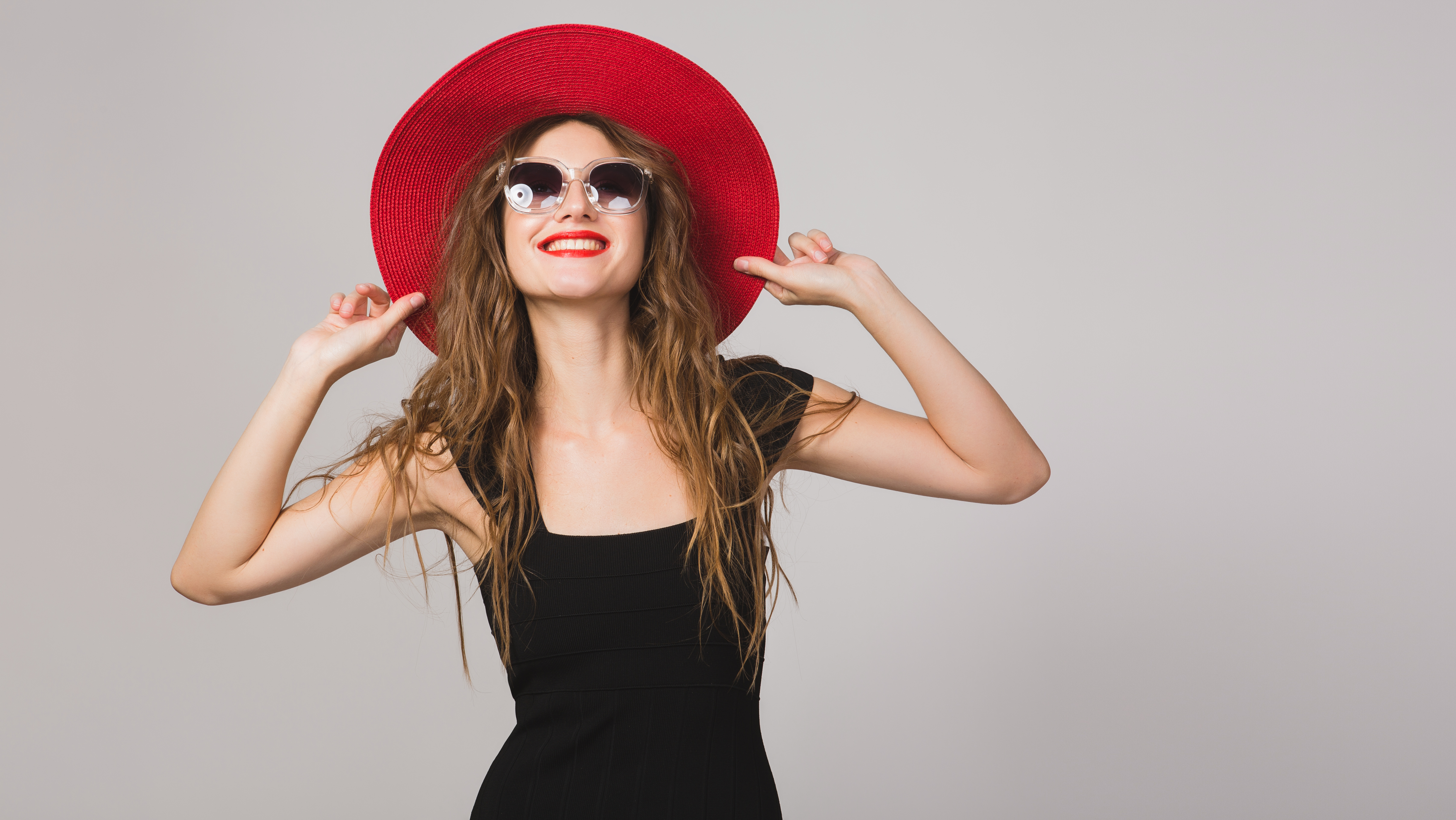 young beautiful stylish woman in black dress, red hat, sunglasses, red lipstick, happy, smiling, sexy, elegant